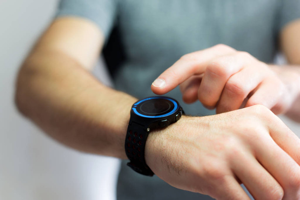 Hand holding black smartwatch with technology screen - 写真・画像
