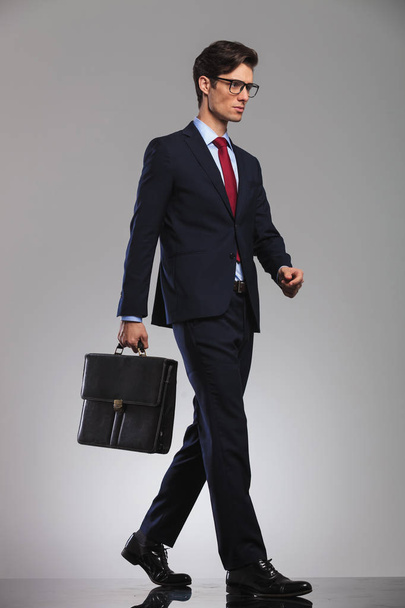 young businessman wearing glasses and suitcase is walking - Foto, Imagem
