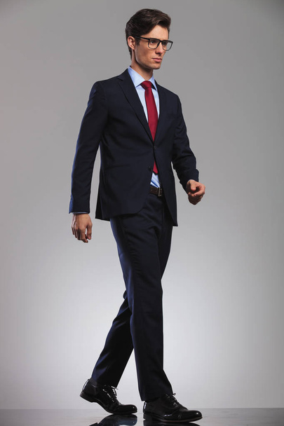 young business man wearing glasses is walking  - Фото, изображение