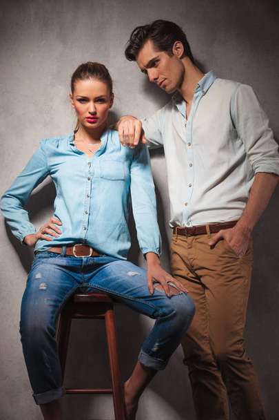 woman sitting on stool while boyfriend leans on her shoulder - Foto, immagini