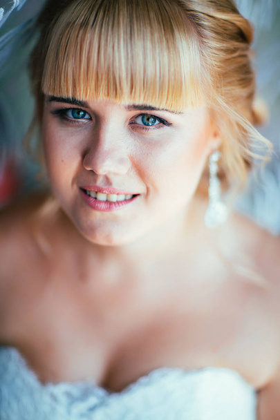 portrait of young beautiful happy bride near the window - Photo, image