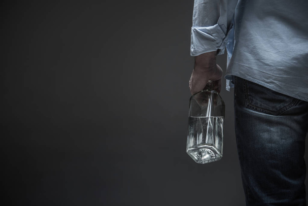 Photo of male back holding bottle in hand - Фото, изображение