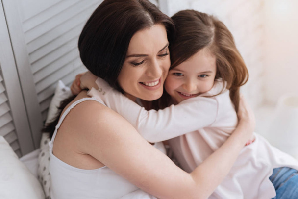 Happy attractive woman embracing her daughter - Photo, Image
