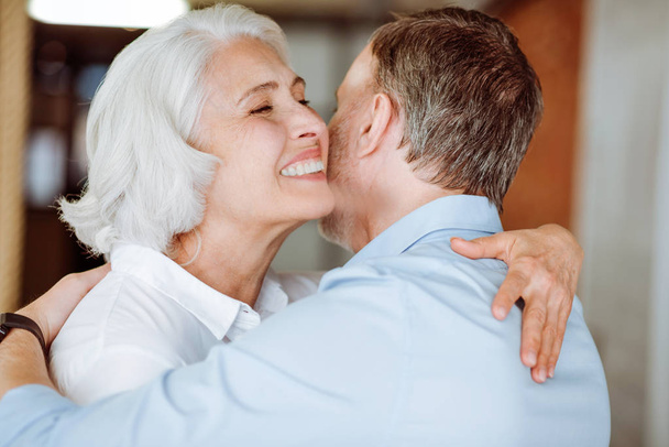 Positive aged couple embracing - Photo, image