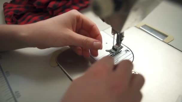 Eine junge Frau fädelt eine Nadel in der Nähmaschine präzise ein - Filmmaterial, Video