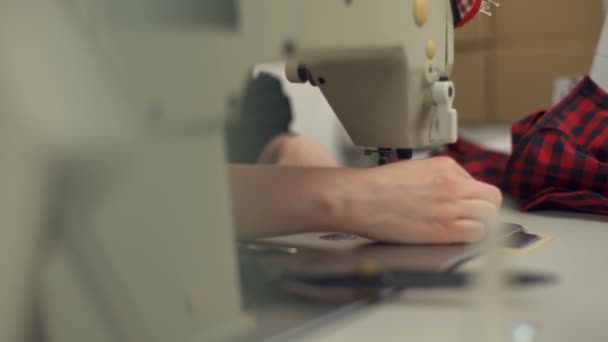 Μια νεαρή μοδίστρα ράψιμο ρούχα και την κοπή με το ψαλίδι - Πλάνα, βίντεο