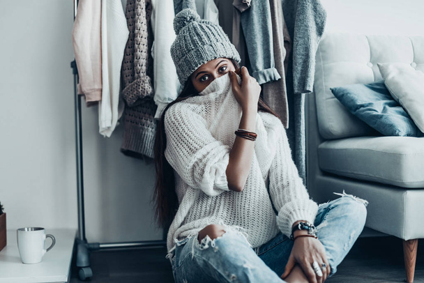 Playful woman covering face by sweater - Photo, Image