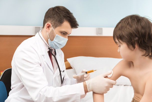 Doctor making injection to boy - Photo, Image