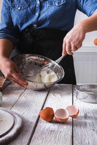 Vrouw baker roer deeg met eieren en meel - Foto, afbeelding