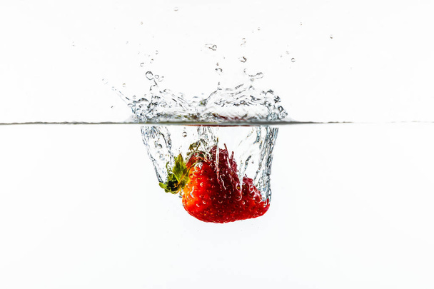 κόκκινη φρέσκια φράουλα σε νερό με πιτσιλίσματα νερού-υγρή τέχνη - Φωτογραφία, εικόνα