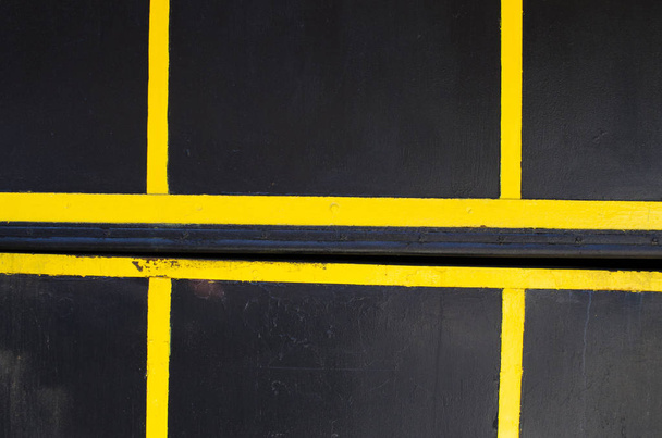 zwarte muur met gele strepen - Foto, afbeelding
