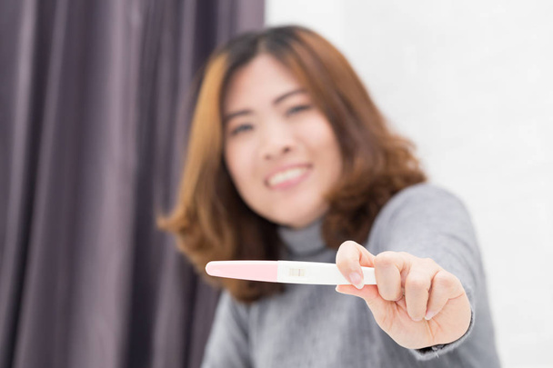 Test ciążowy szczęśliwy azjatyckie kobietę. - Zdjęcie, obraz