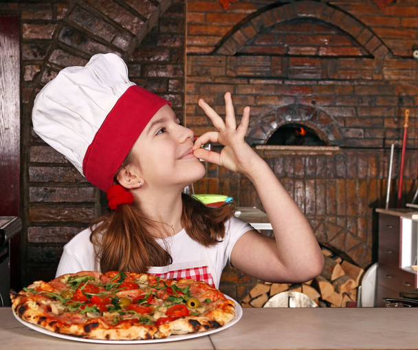 ευτυχισμένη κοριτσάκι μάγειρας με πίτσα και εντάξει το χέρι συνδεθείτε σε πιτσαρία - Φωτογραφία, εικόνα