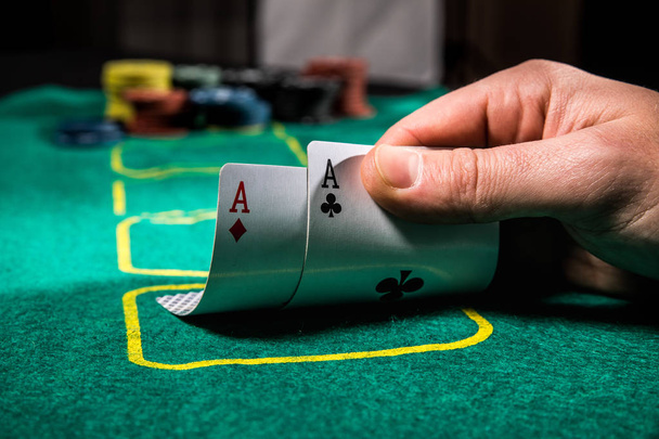 close up of poker player with two aces playing cards and chips at green casino table - Photo, Image