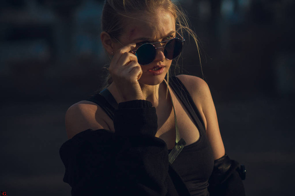 Portrait  of cosplayer  girl with sunglasses in costume Croft. - Photo, Image