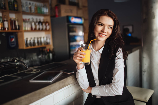 Healthy eating - young woman keeping orange juice at restaurant bar - Фото, изображение