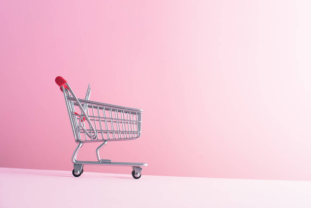 Carrito de compras sobre fondo rosa
 - Foto, imagen
