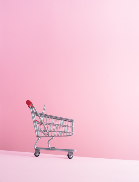 Shopping cart over pink background - Photo, Image