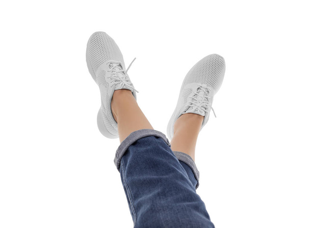 Female feet in sneakers raised up. - Photo, image
