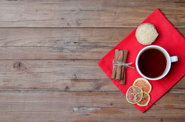 A cup of hot tea and spices on a wooden table. - Valokuva, kuva