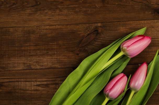 Pink tulips on a wooden background. Mother's Day. Spring flowers - Фото, изображение