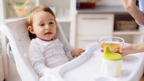 mother feeding baby with puree at home - Video, Çekim