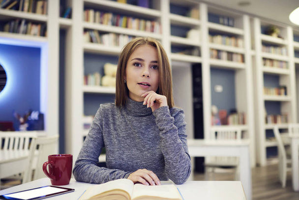 Přemýšlející žena psaní a připojen k rychlé 5g bezdrátové v univerzitní knihovně wifi zóna - Fotografie, Obrázek