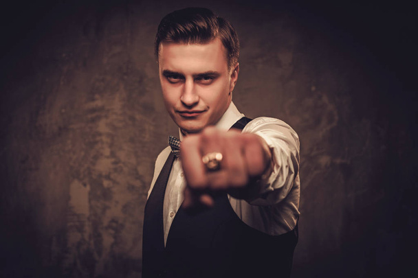Sharp dressed man wearing waistcoat and bow tie pointing with his finger - Photo, Image