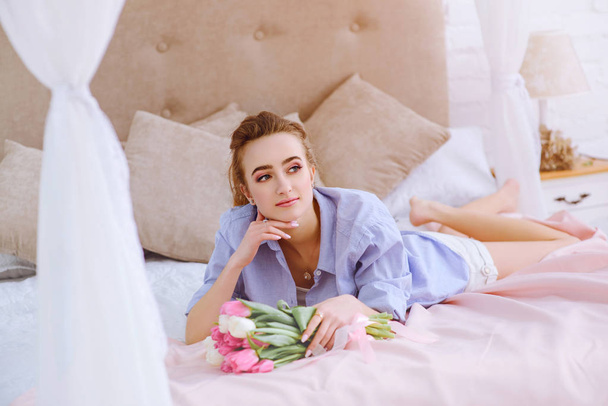 jeune fille avec bouquet de fleurs sur le lit
 - Photo, image