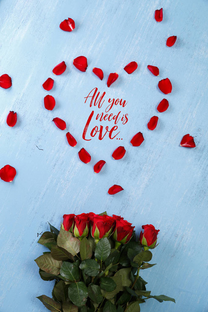 Heart of red rose petals on blue wooden board. - Valokuva, kuva