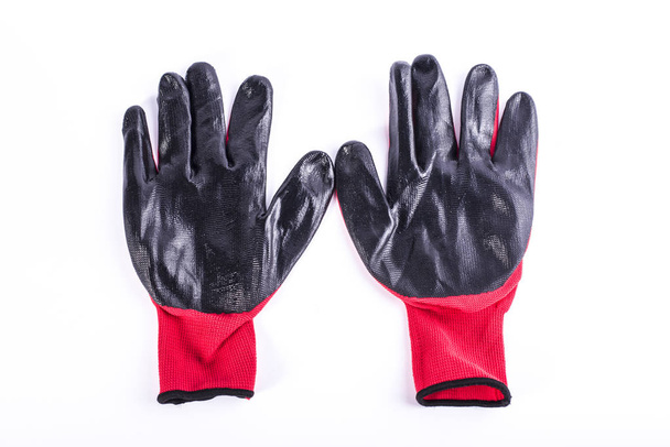 Kleding, bescherming voor handen rode en zwarte handschoenen voor industriële werk werken.  - Foto, afbeelding
