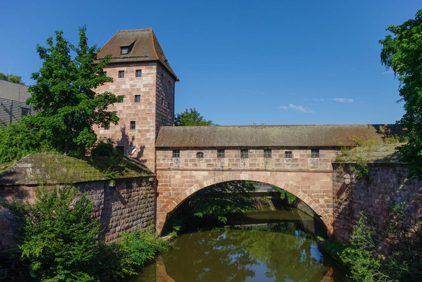 Oude stadsmuren met een boog weerspiegeld in de rivier Pegnitz, in de buurt van Steubenbrucke brug, historische binnenstad, Neurenberg, Beieren, Duitsland - Foto, afbeelding