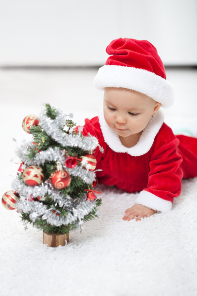 My first christmas - baby girl with small decorated tree - Foto, Bild