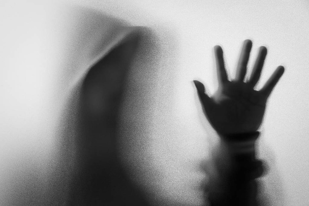 Θόλωσης σκιάς του ανθρώπου τρόμου σε μπουφάν με κουκούλα. Ένα τα χέρια για την g - Φωτογραφία, εικόνα