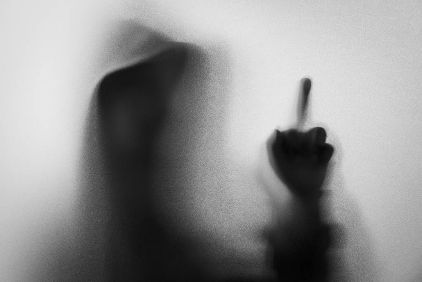 Shadow blur of horror man in jacket with hood.Middle finger symb - Photo, Image