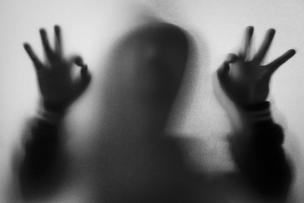 Θόλωσης σκιάς του ανθρώπου τρόμου σε μπουφάν με κουκούλα. Δάχτυλο κάνουμε ως μια sym - Φωτογραφία, εικόνα