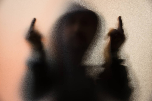 Θόλωσης σκιάς του ανθρώπου τρόμου σε μπουφάν με κουκούλα. Μεσαίο δάχτυλο η συ - Φωτογραφία, εικόνα