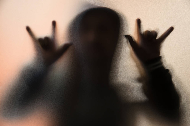 Schatten Unschärfe des Horror-Mannes in Jacke mit Kapuze. Finger tun als Sym - Foto, Bild