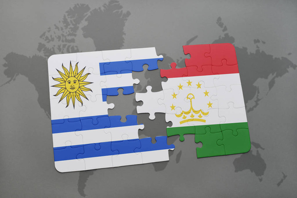 παζλ με την εθνική σημαία της Ουρουγουάης και του Τατζικιστάν σε έναν παγκόσμιο χάρτη - Φωτογραφία, εικόνα