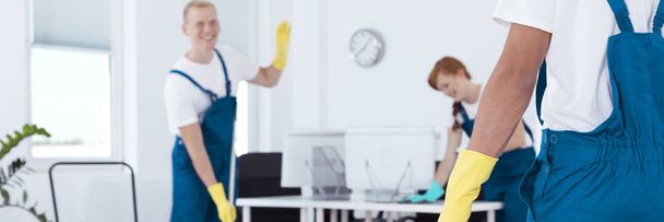 Greeting a colleague while cleaning - Foto, Imagen