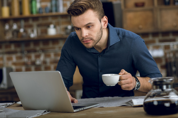 Man drinken koffie en het gebruik van laptop - Foto, afbeelding