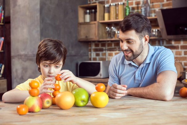 Father and son with fruits - Фото, изображение
