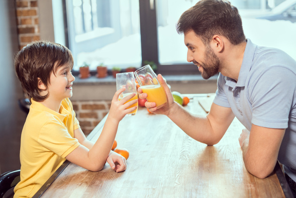 Отец и сын пьют сок - Фото, изображение