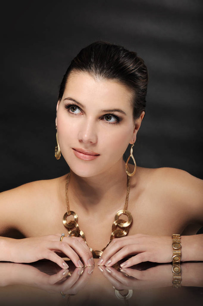 beautiful woman in golden jewelry - Foto, Imagen
