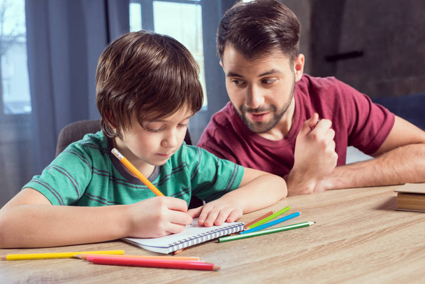 father helping son doing homework  - Photo, image
