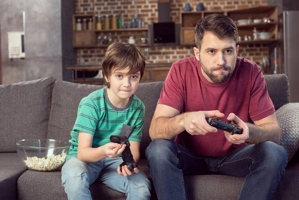 Vader en zoon spelen videospel - Foto, afbeelding