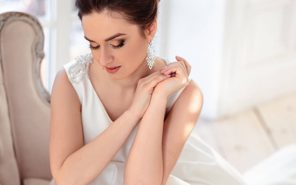 Nahaufnahme Porträt der schönen brünetten Braut mit eleganter Frisur und Make-up trägt lange Luxus-Hochzeitskleid - Foto, Bild