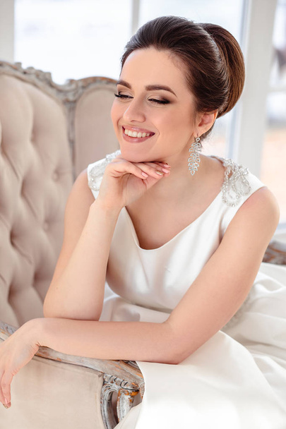 close-up portrait of beautiful brunette bride with elegant hairstyle and makeup wearing long luxury wedding dress - Zdjęcie, obraz