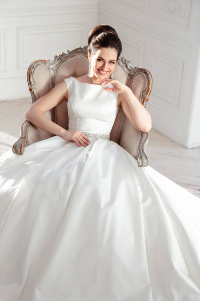 portrait of beautiful brunette bride with elegant hairstyle and makeup wearing long luxury wedding dress - Фото, зображення
