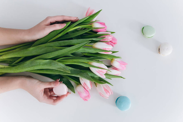 handen met tulpen en macaron - Foto, afbeelding
